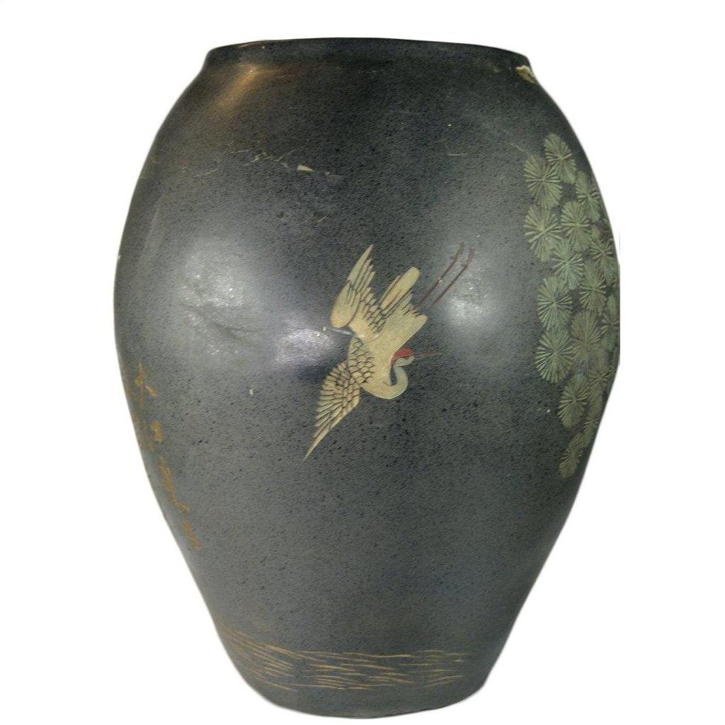 Black ceramic vase with crackled finish, light paint loss, and a painted crane among green foliage.
