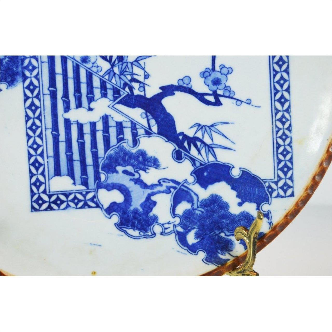Blue and white ceramic Igezara transferware plate with ridged iron-brown edge and floral, geometric patterns, close-up.