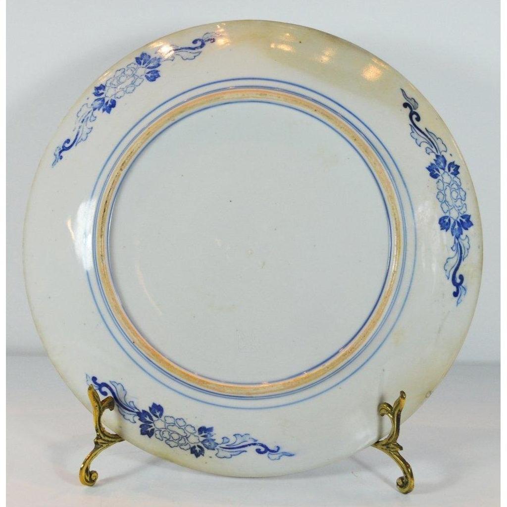 Blue floral Igezara transferware plate with ridged iron brown edges on a decorative metal stand.