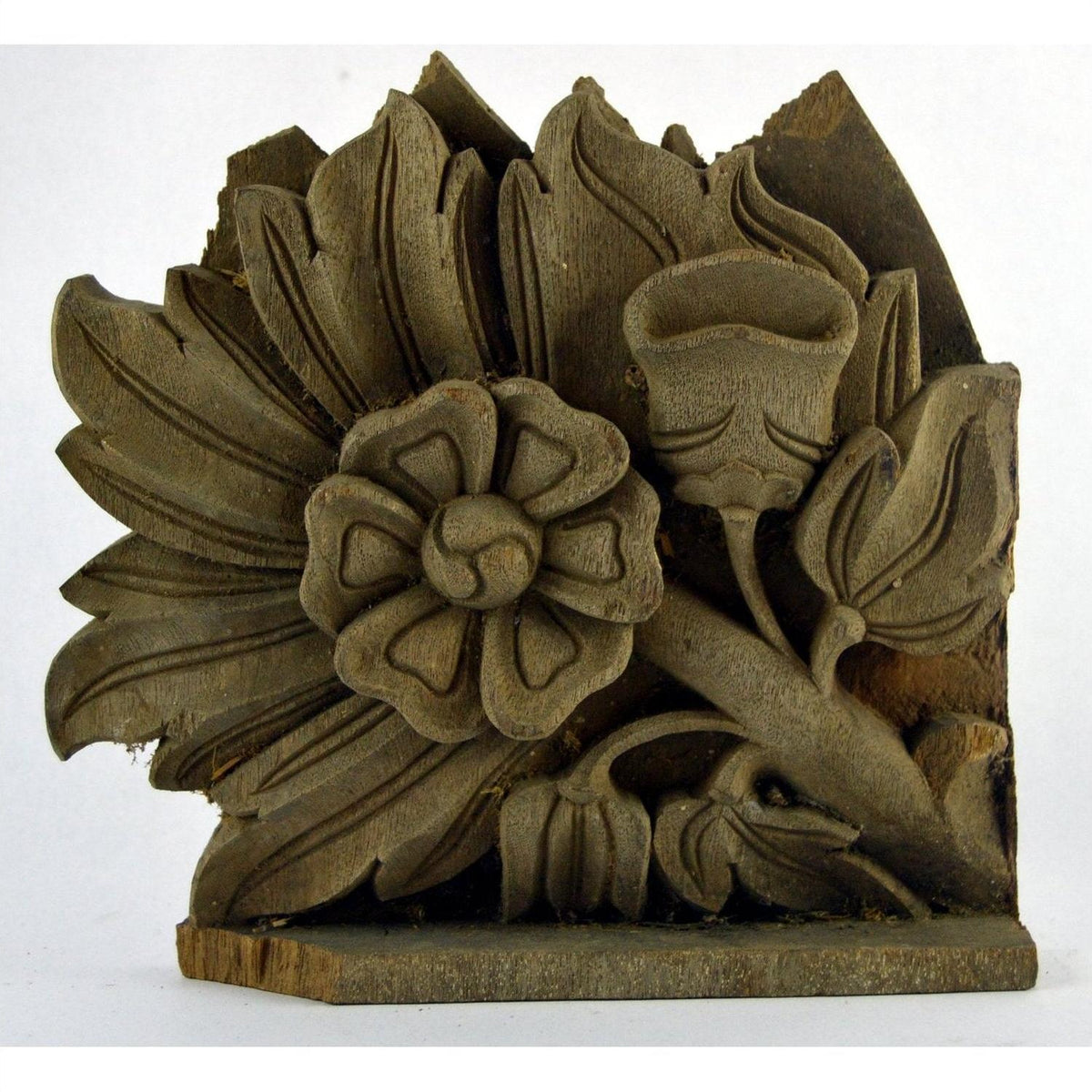 Brown hand carved wooden temple plaque with stylized floral and leaf motifs, weathered upper edge, close-up view.