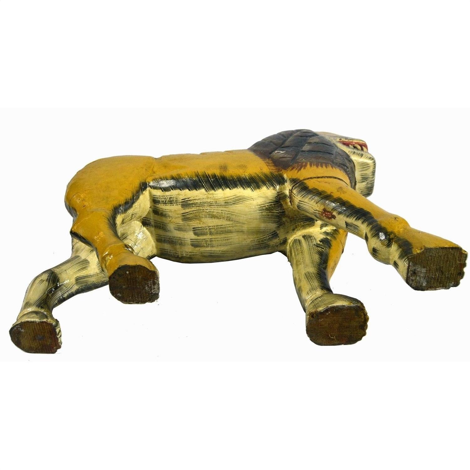 Brown wooden carved lion with loose joints lying on its side, white background.