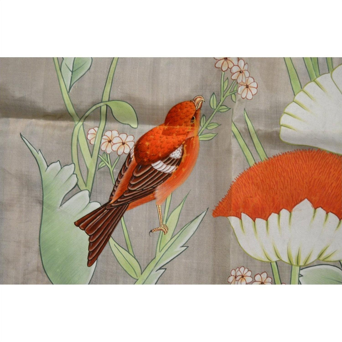 Red-orange bird with light paint loss on a branch with flowers, India silk tapestry background.