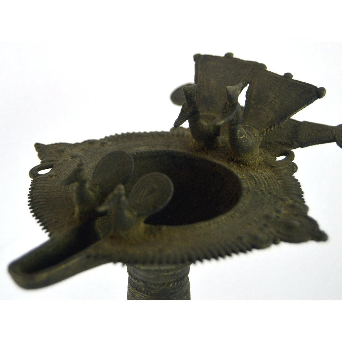 Close-up of a brass Indian oil burner with bird and fan designs on top, 5 1/4 inch diameter.