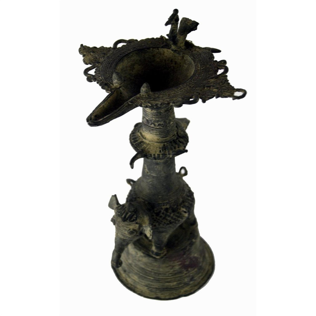 Close-up of dark brass Indian oil burner with intricate carvings and animal-shaped figures on the sides.