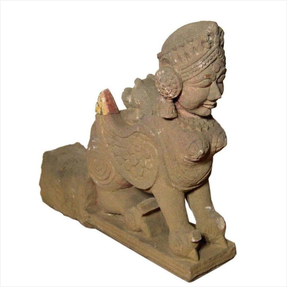 Gray stone Indian 19th-century hand-carved sphinx sculpture with tiara and earrings, animal body, close-up view.