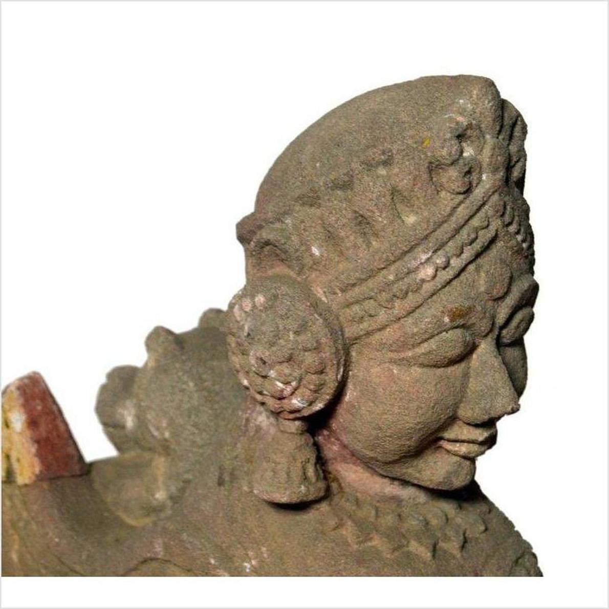 Close-up of gray stone Indian sphinx sculpture with tiara and earrings, hand-carved, 19th century, facing right.