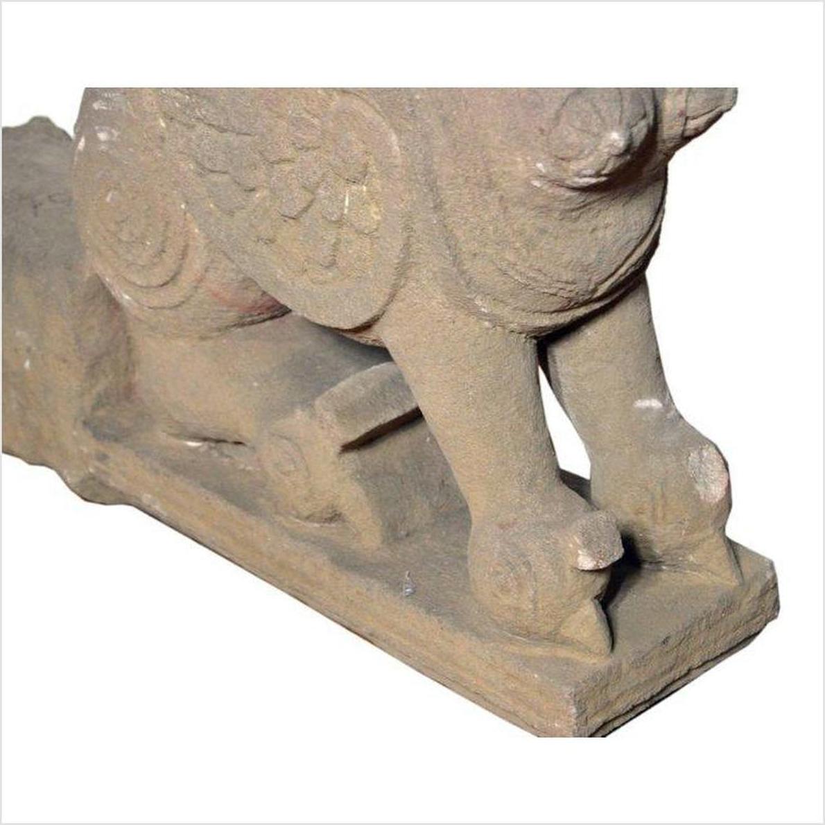 Gray stone 19th-century Indian sphinx sculpture with tiara and earrings, close-up on intricate carved details.