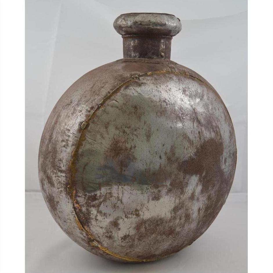Oval-shaped antique Indian metal water jug with a rustic finish, close-up view.