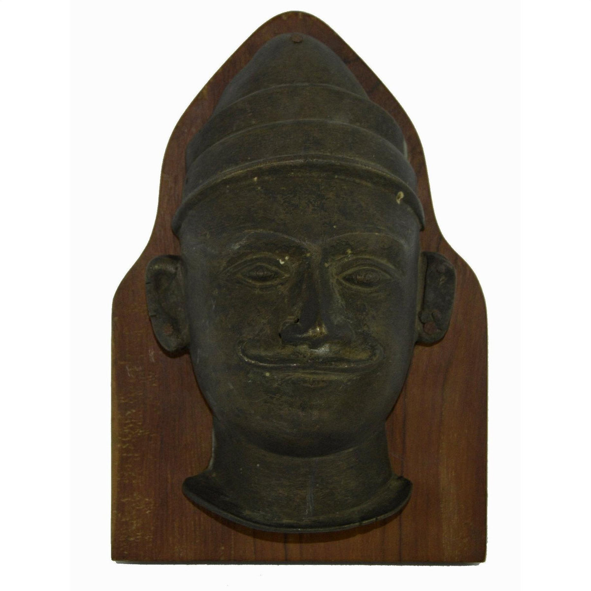 Close-up of dark brass bas-relief plaque showing a sculpted head with pointed hat, 8x4x1.5 inches, very good condition.