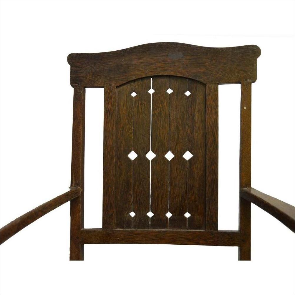 Dark wood Indonesian Java chair with carved arch and diamond cut-out backrest, front view on white background.