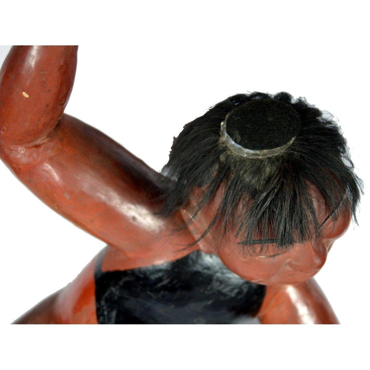 Reddish-brown and black hand carved lacquered Japanese boy figure with black hair and raised arm, top view.