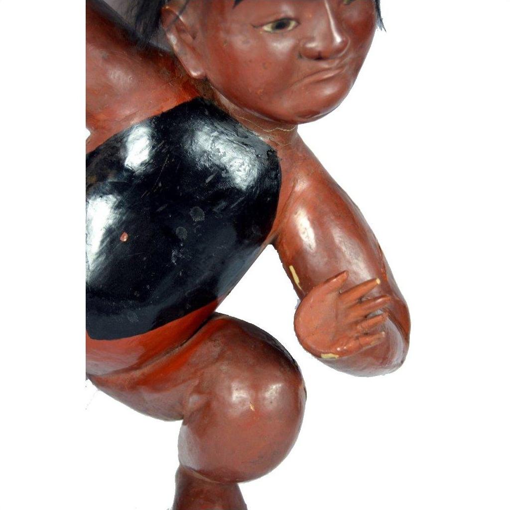 Close-up of brown and black hand carved Japanese lacquered boy sculpture, bent arm visible, in good condition.