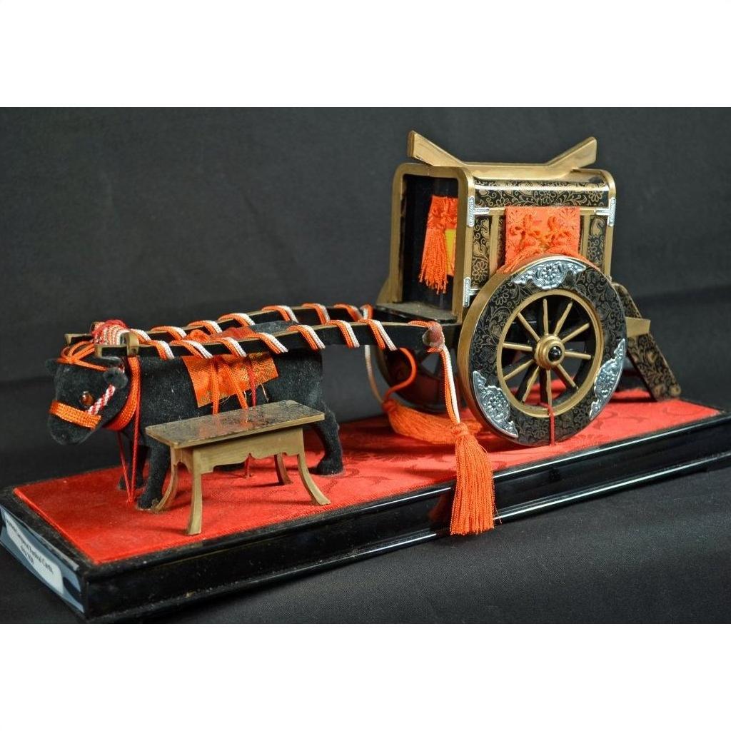 Black lacquered Japanese festival cart with red and gold accents, close-up view.