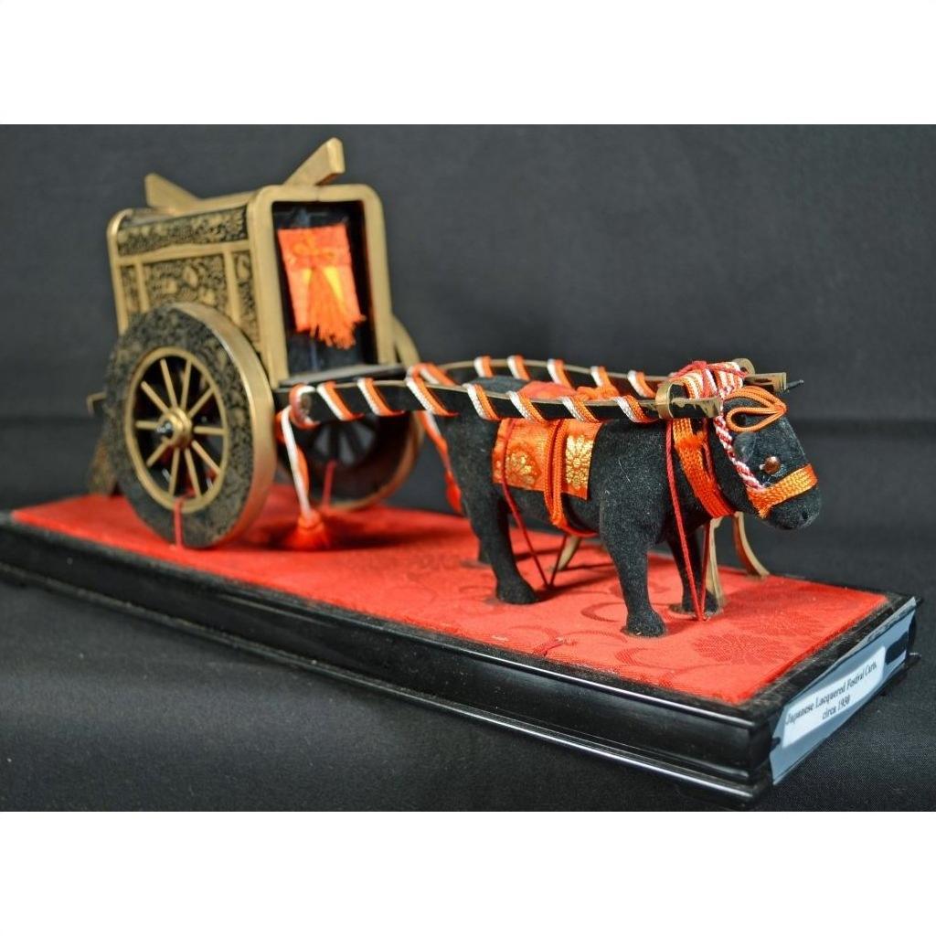 Close-up of a red and black lacquered Japanese festival carts model with ornate decorative details on base.