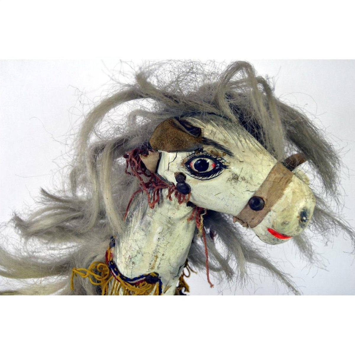 Close-up of a Japanese two-headed horse toy with tangled gray hair, painted faces, and visible neck stitching.