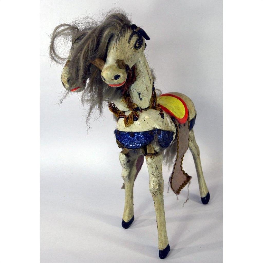 Brown two-headed horse toy with tangled mane and blue sequined saddle on white background.