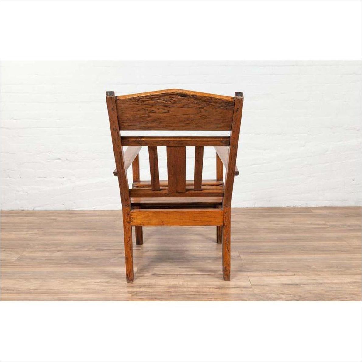Brown wooden lounge chair with slanted back, viewed from behind on a wooden floor.