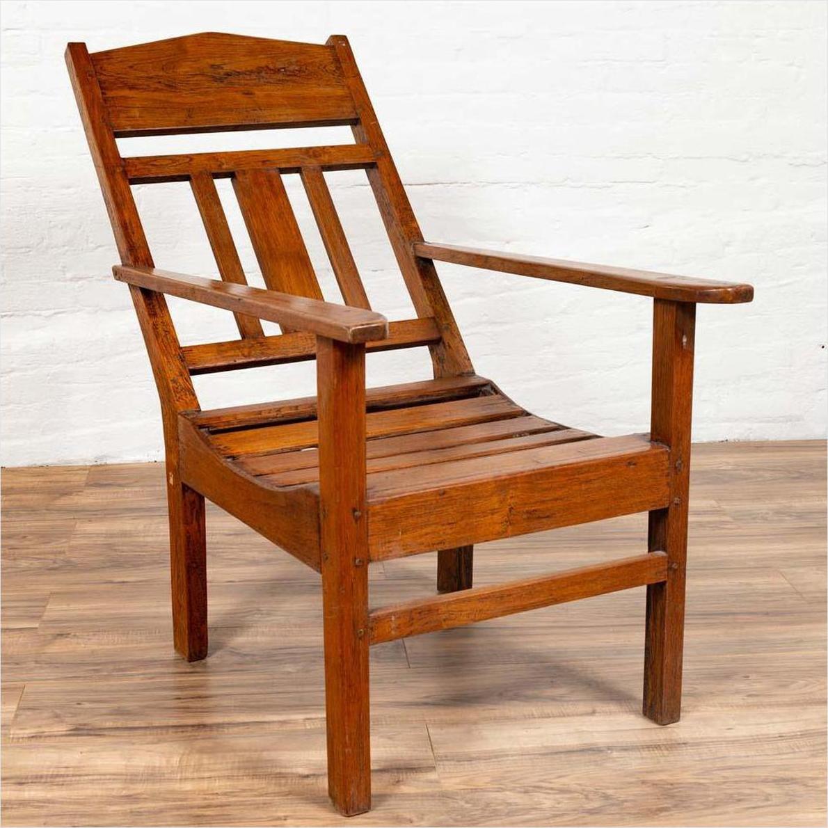 Brown wooden lounge chair with slanted back on wood floor.