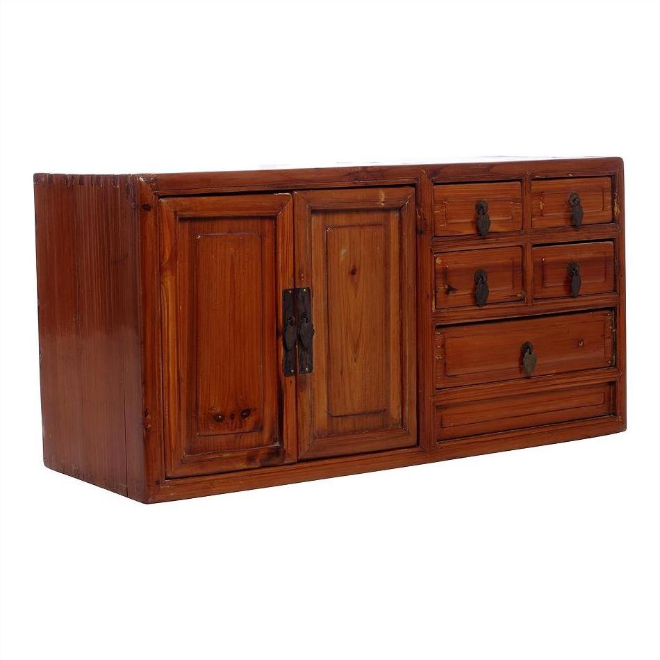 Brown wood jewelry box with double left doors and five assorted-size right drawers, close-up.