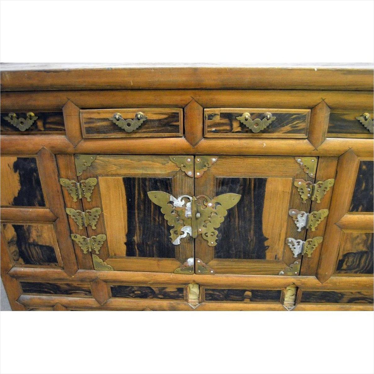 Brown wood chest close-up with brass butterfly hardware on drawers and doors, antique Korean, 19th century.