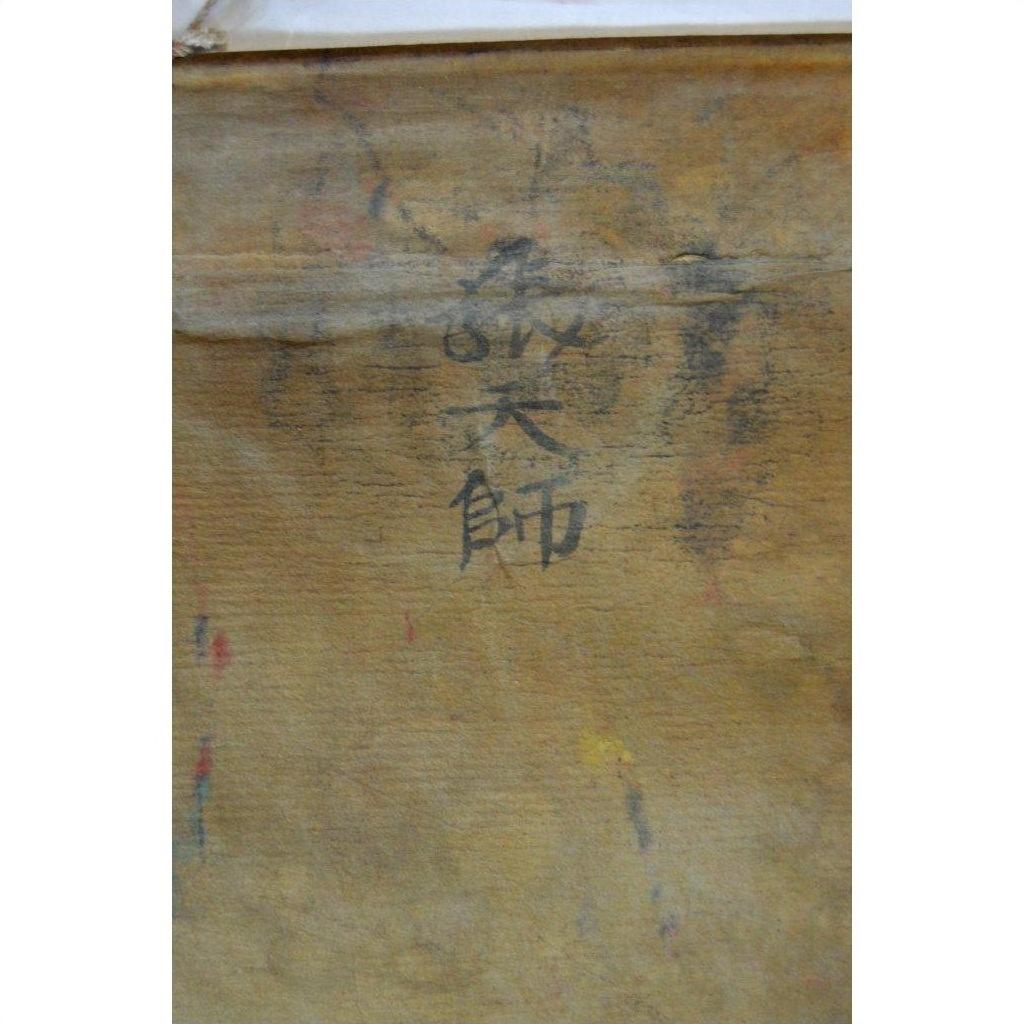 Brown parchment painting with faint vertical black characters at the center, traditional Laotian art.