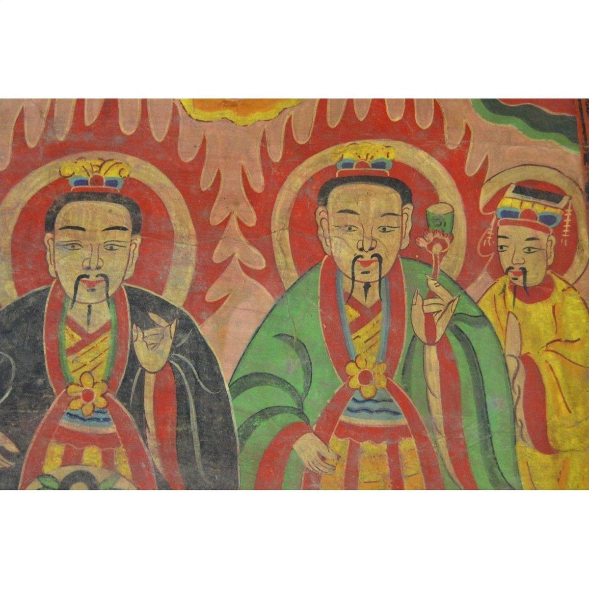 Colorful Laotian parchment painting featuring three crowned, haloed men in robes, close-up view.