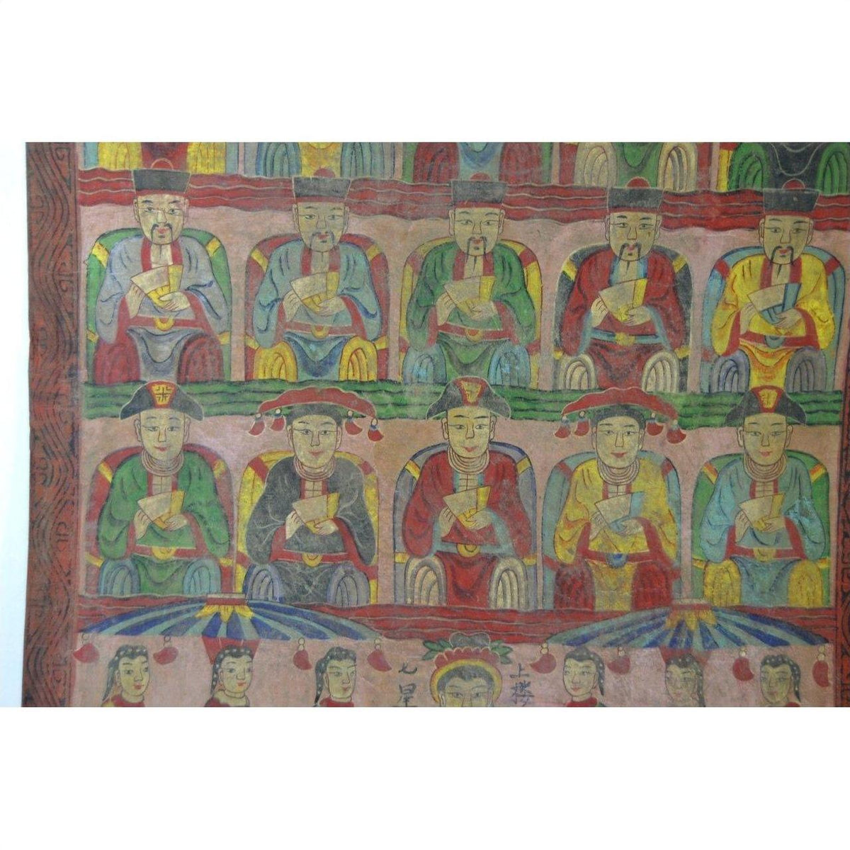 Colorful Laotian parchment painting with rows of figures in traditional attire holding objects, various styles shown.