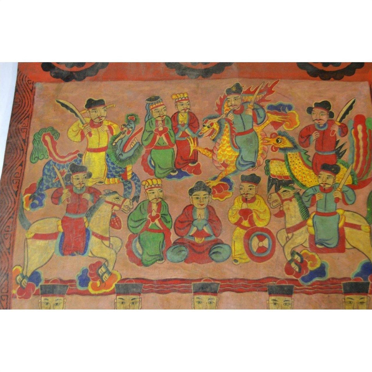 Multicolored parchment painting showing figures in traditional dress and mythical creatures with prayer gestures.