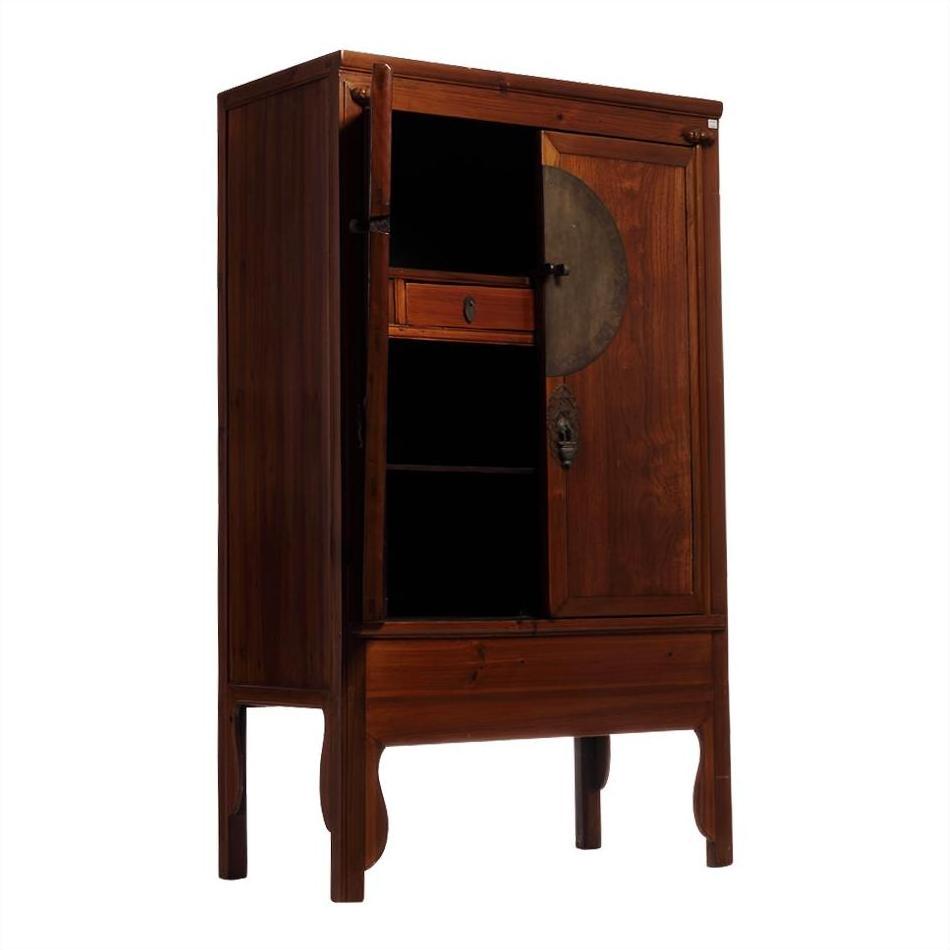 Dark wood Chinese armoire with round medallion handle, open door revealing interior shelves and a drawer, 19th-century.