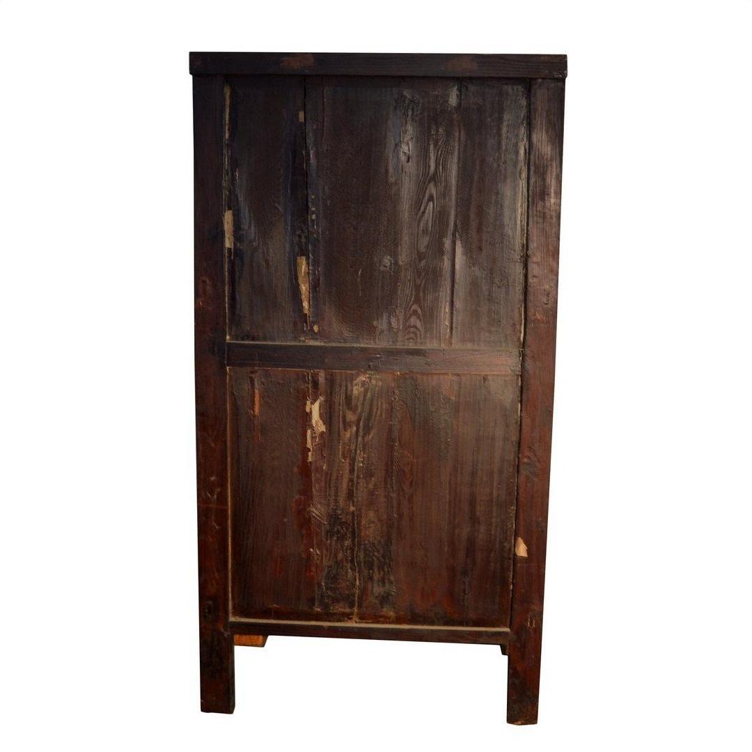 Weathered wood armoire with carved panels, scratches, and dark stains against a white background.