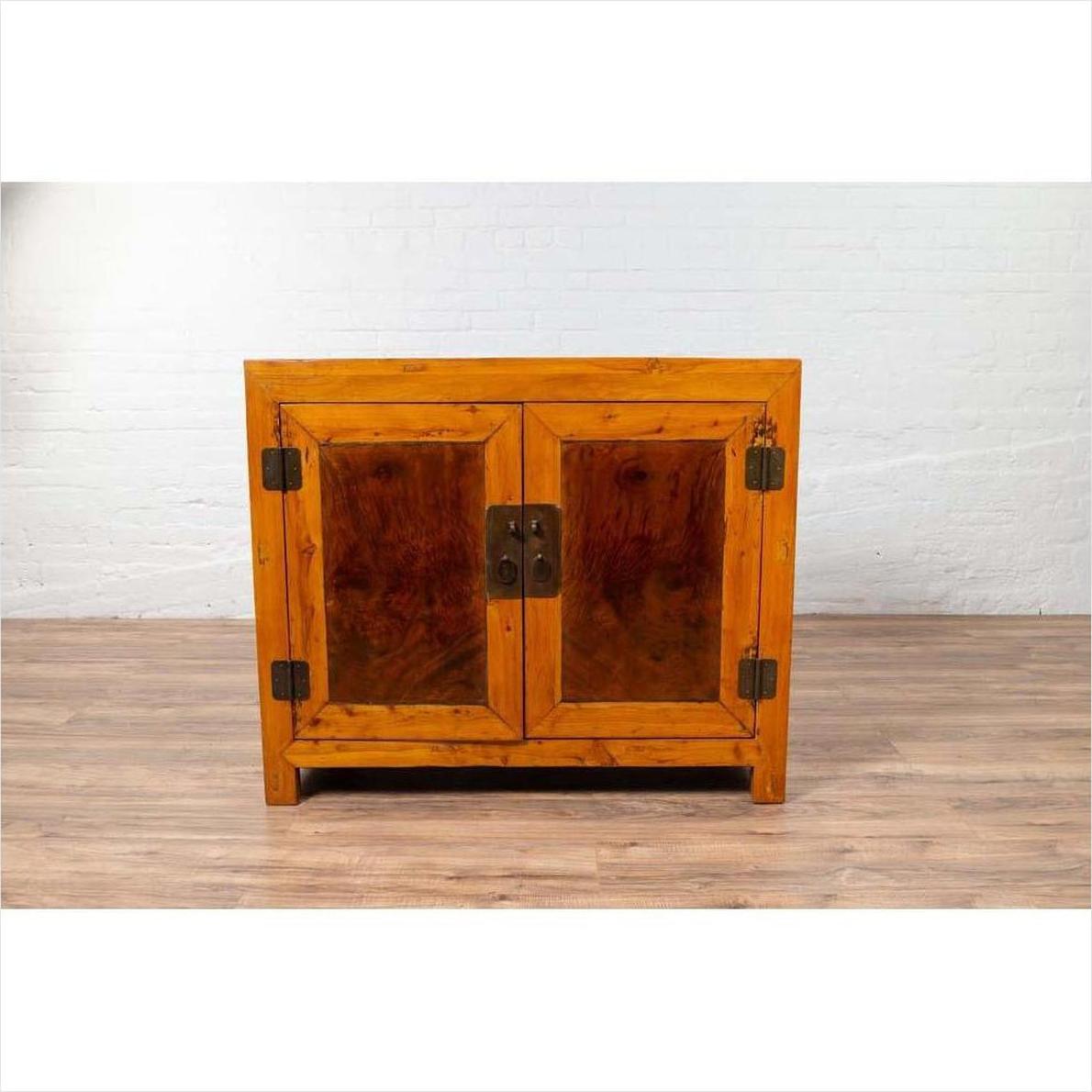 Brown burl and elm wood two-toned cabinet with doors on a hardwood floor indoors.