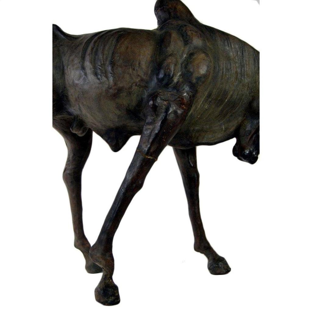 Brown leather gnu sculpture with slender body and lowered head, displayed against a plain white background.