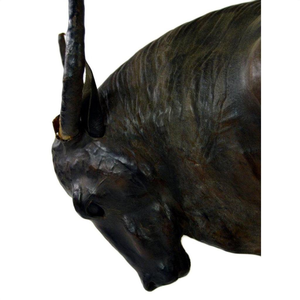 Close-up of a brown leather gnu sculpture with lowered head and one visible horn.