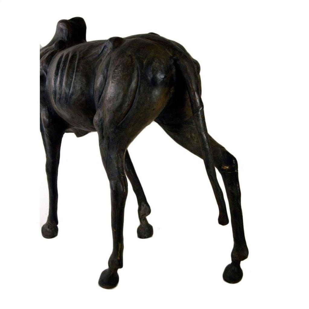 Brown leather gnu sculpture showing back legs, ribcage, and torso on a white background.