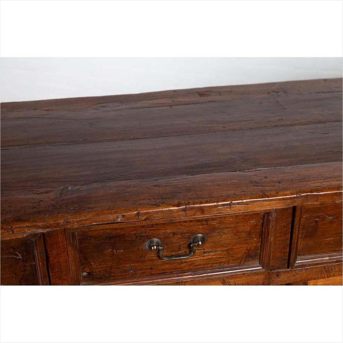 Close-up of brown teak wood cabinet with polished finish, four drawers, and double doors.