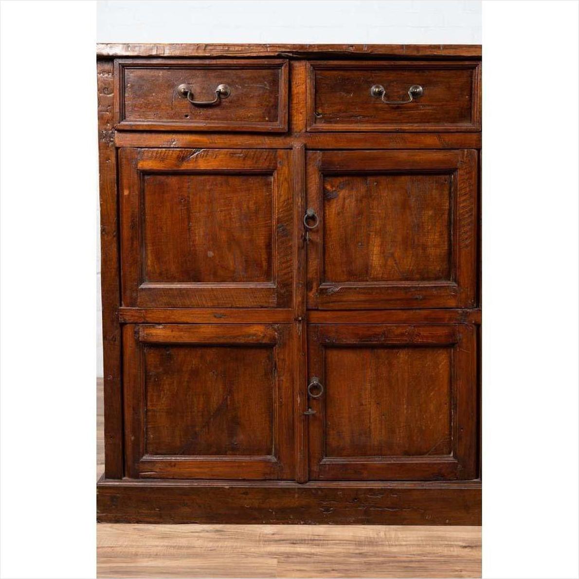 Brown teak wood cabinet with four drawers and four double doors, large size, set against a plain background.
