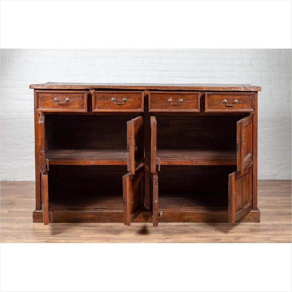 Brown teak wood cabinet with four drawers and four double doors, empty shelves visible inside.
