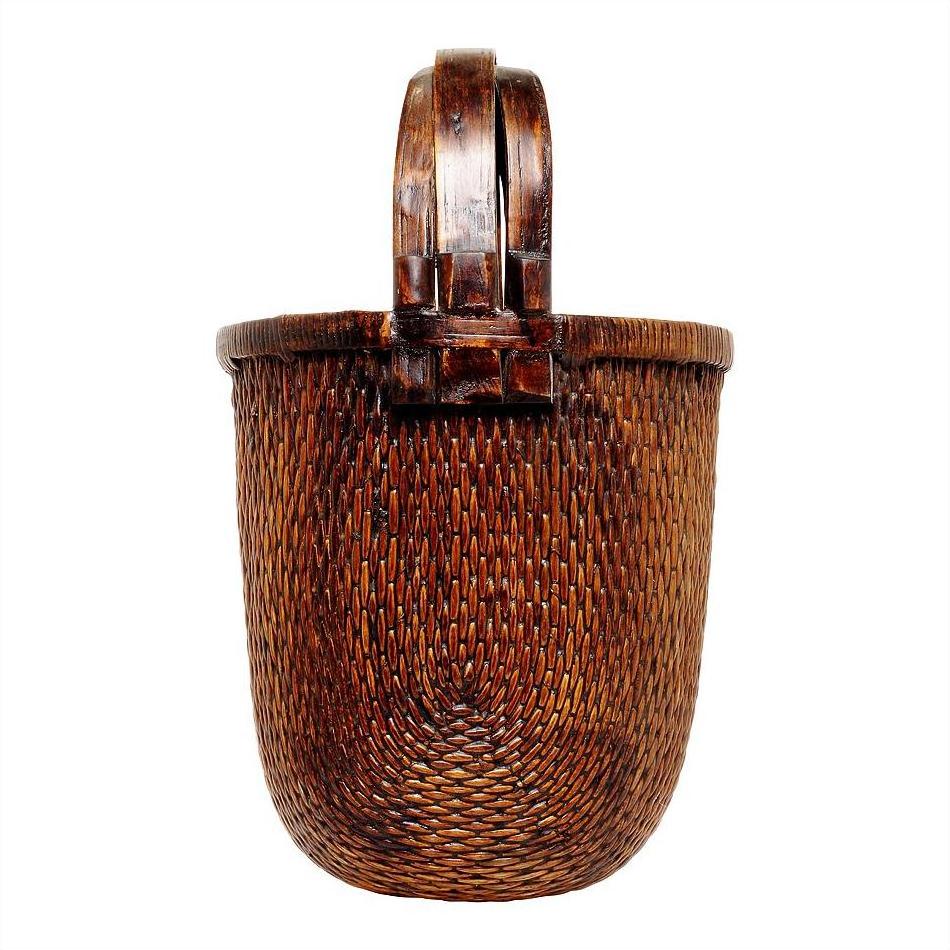 Natural woven basket with sturdy handle, large size, for magazines, on plain white background.