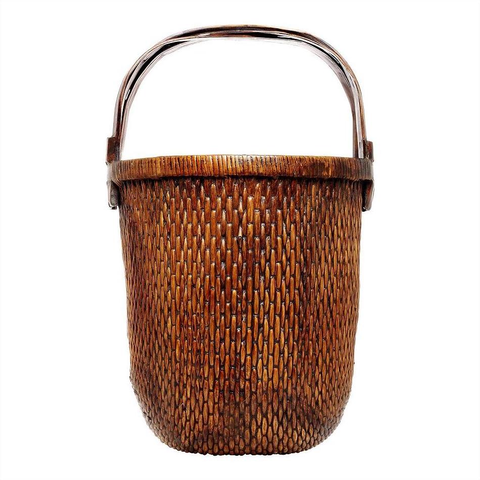 Natural woven basket with sturdy handle, suitable for storing magazines, displayed on a white background.