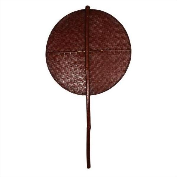 Brown woven fan with a round shape and long handle on a white background.
