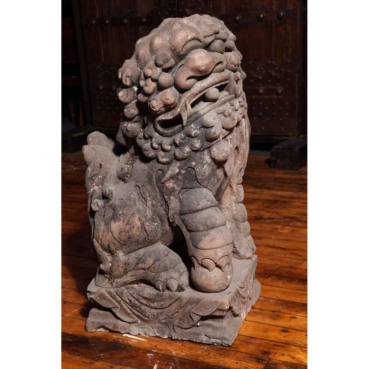 Gray stone lion statue with curled mane on a detailed carved wooden floor, Late Ming Dynasty, 16th-17th c. China.
