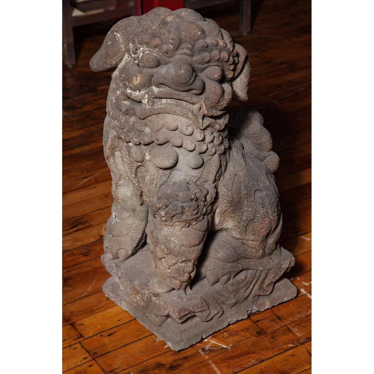 Gray stone lion sculpture on wooden floor, Ming Dynasty Chinese antique, carved details visible.