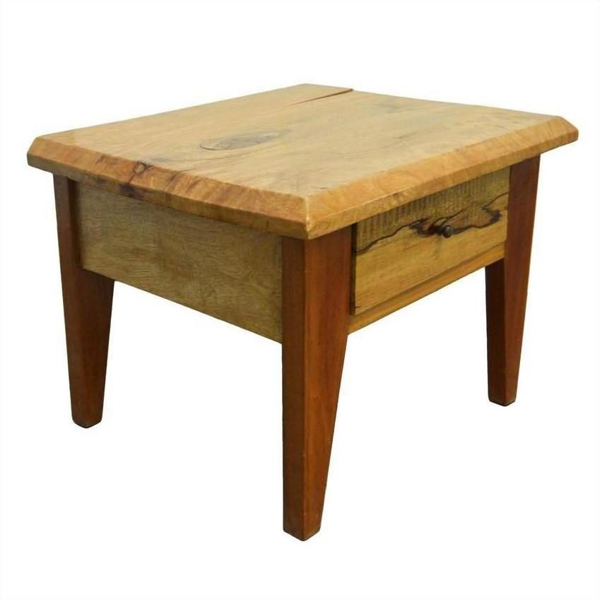 Brown mango wood side table with four legs, rustic finish, front drawer with brass pull, indoors.