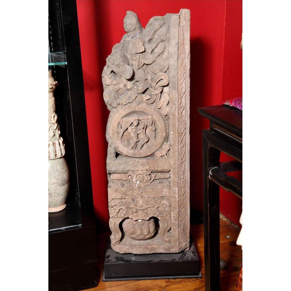 Brown wood Ming Dynasty Chinese temple carvings with figures, floral, and circular motifs on black bases, close-up.