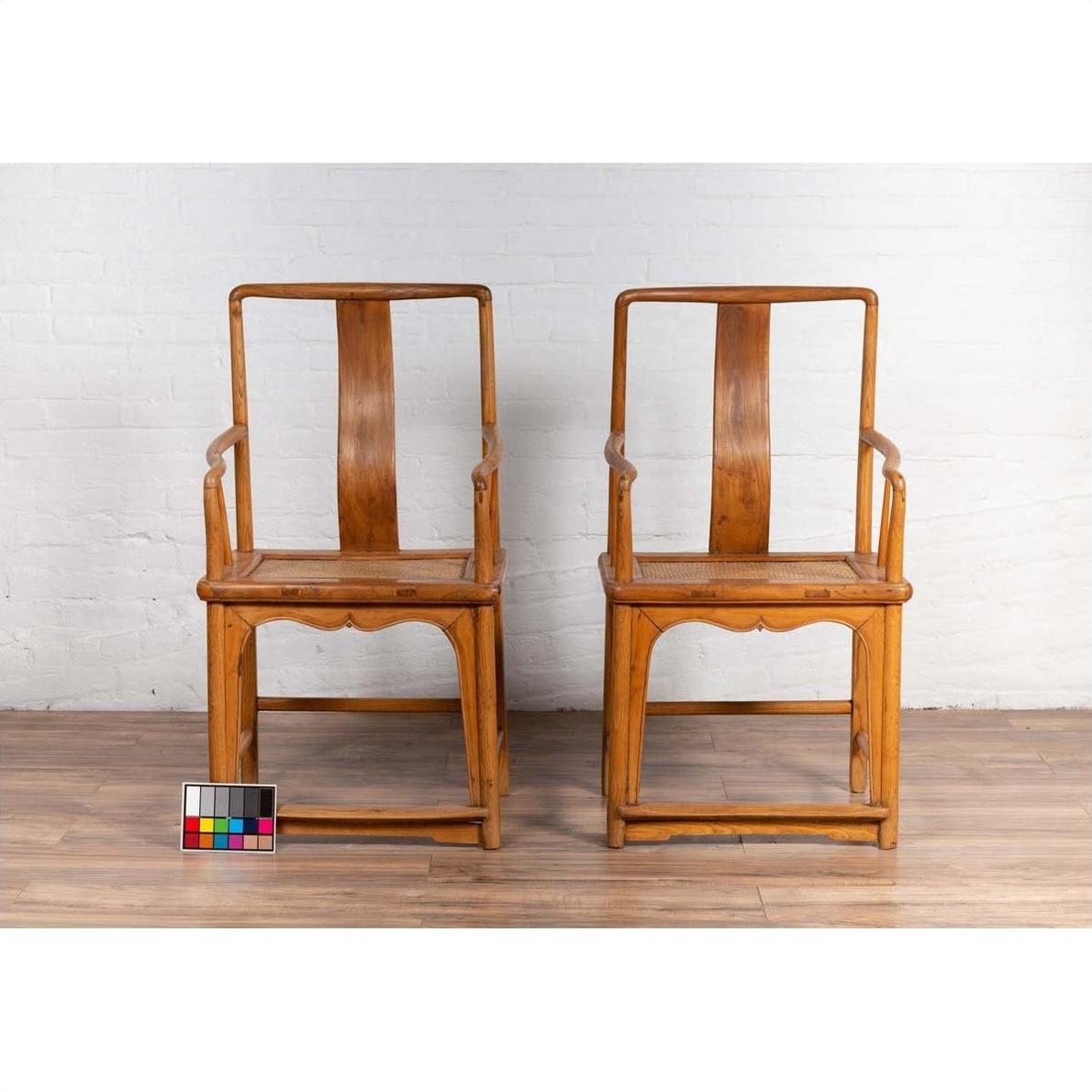 Brown wood and rattan wedding armchairs in Ming Dynasty style with curved arms, on wooden floor, color chart in front.