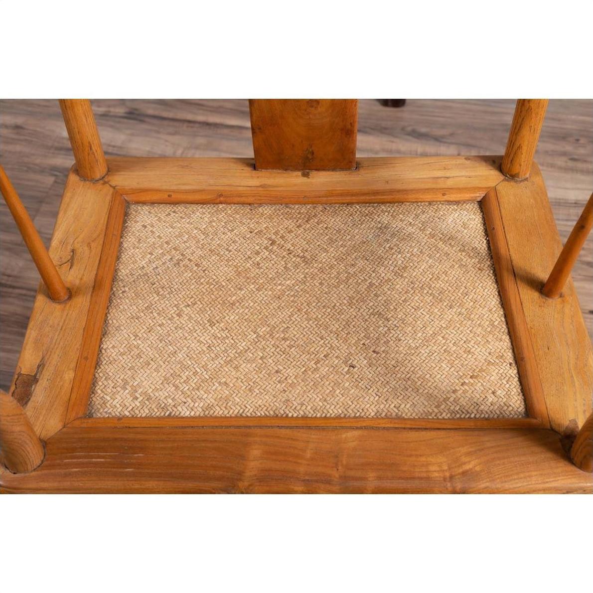 Brown wood and woven rattan close-up of wedding armchair seat on a wood-patterned floor.