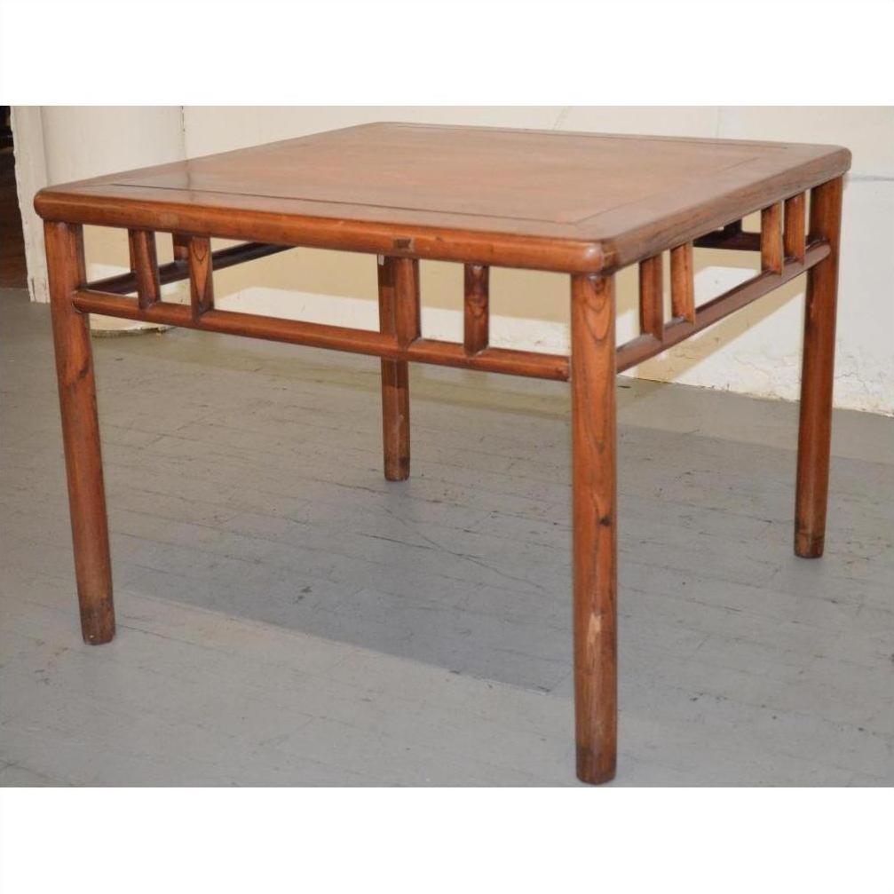Brown Ming style wood coffee/side table with straight legs and geometric details on a gray floor.