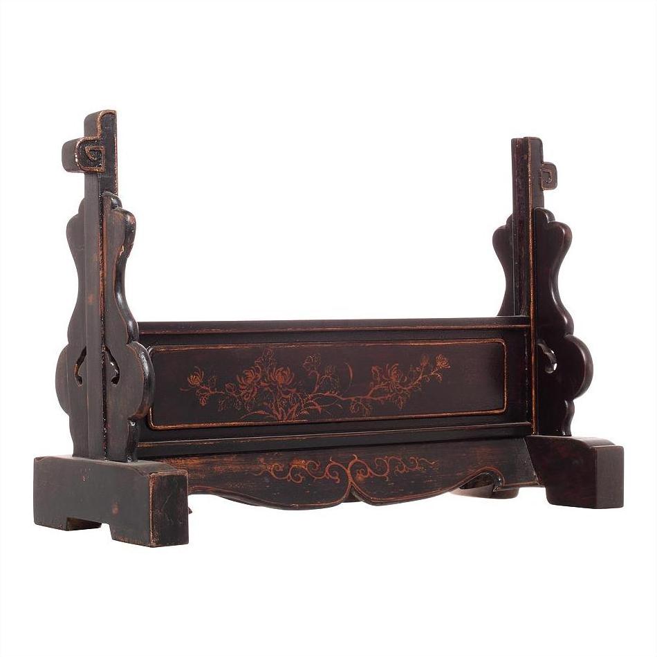 Dark wood mirror stand with floral carvings, black lacquer accents, and cut-out side panels, close-up view.