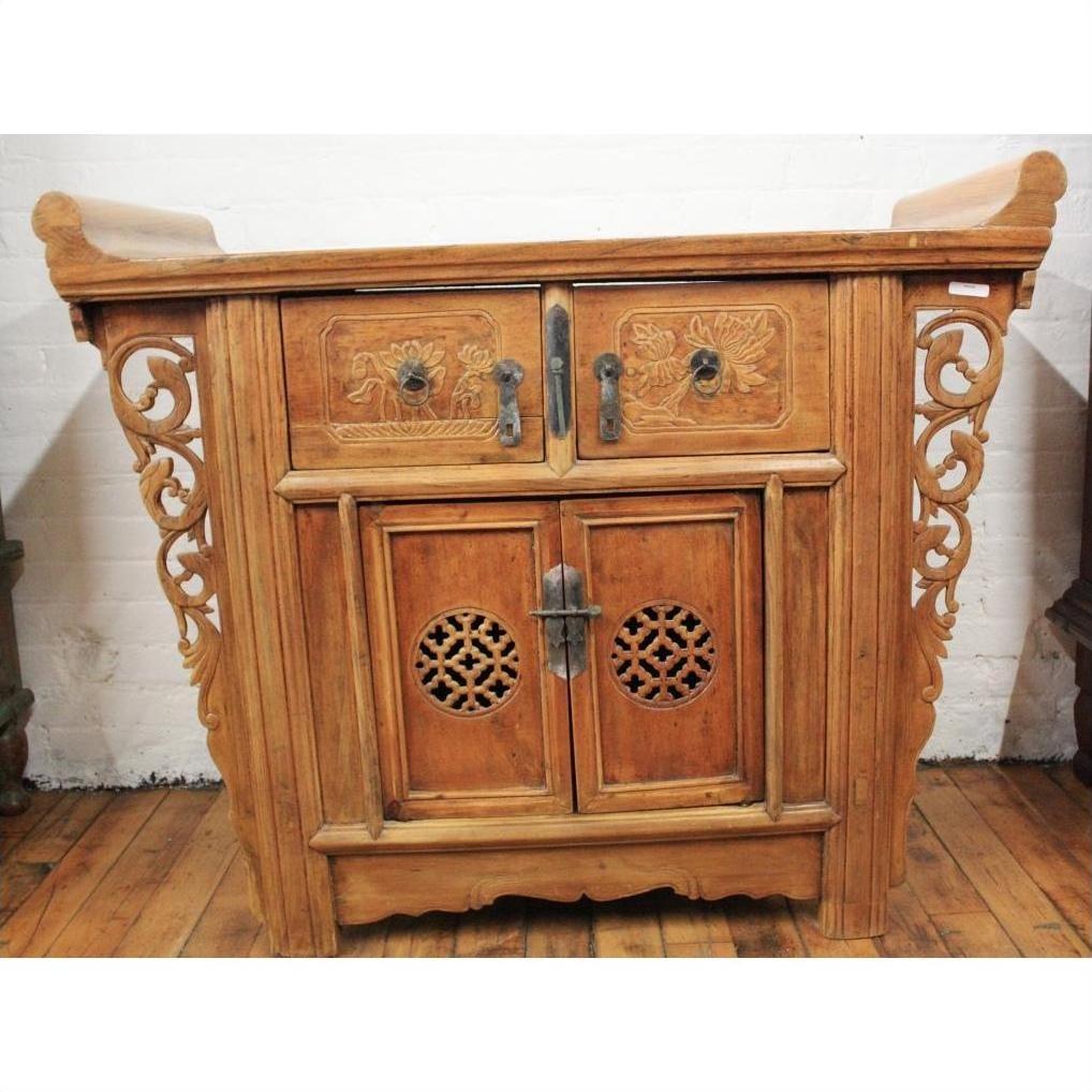 Natural elmwood altar cabinet with carved floral details, two drawers, vented doors, and spandrels, front view.