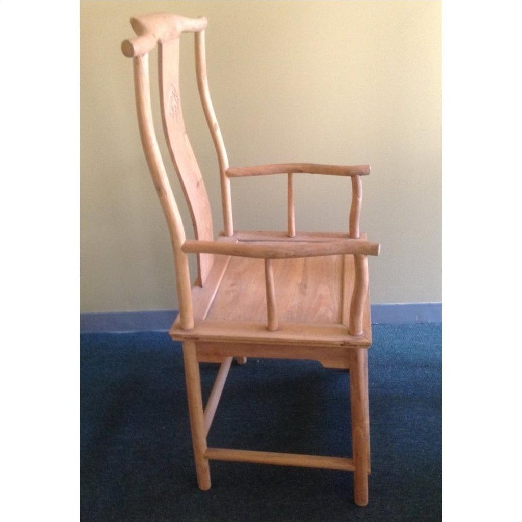 Natural wood yoke back chair with a tall, curved backrest against a pale yellow wall.